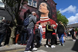 Fanoušci Liverpoolu chodí kolem nástěnné malby kapitána Liverpoolu Virgil Van Dijk